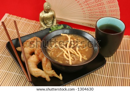 A delicious Chinese dinner of hot & sour soup, fried shrimp and tea.
