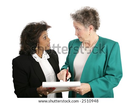 A female business team discussing a report.  Isolated on white.