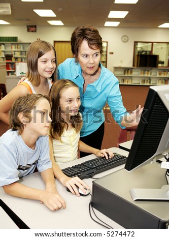 A teacher instructing kids on using the computer.