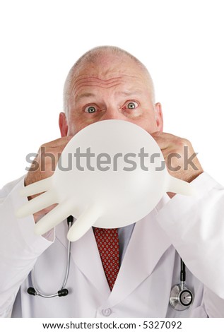 Portrait of a doctor blowing up a rubber glove and making a funny face.  White background