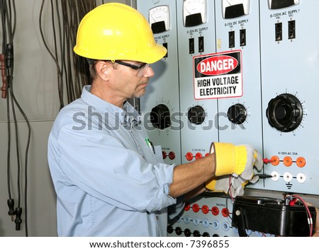 Actual electrician working on an industrial power distribution center. All work shown is being performed according to industry code and safety standards.