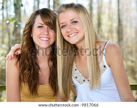 Portrait of beautiful teen sisters in natural setting.  Focus on blond girl in foreground.