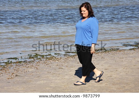 Beautiful plus sized model taking a walk by the sea.