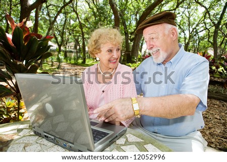 Senior couple on their laptop computer in a beautiful, natural setting.