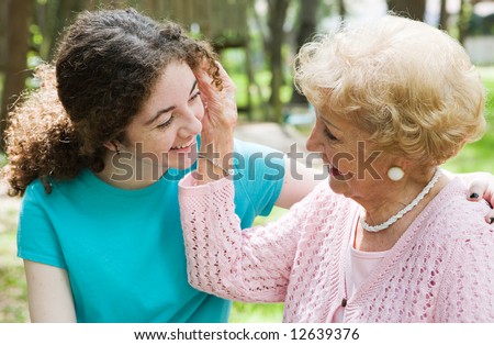Beautiful teen girl and her loving grandmother smiling at each other.