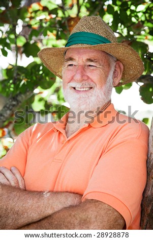 Handsome senior man in a straw hat looking off camera.