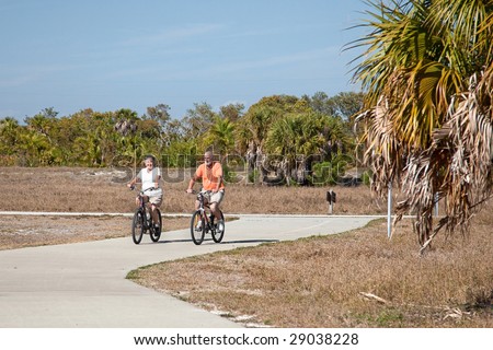 Active senior couple riding their bicycles on a beautiful sunny day.