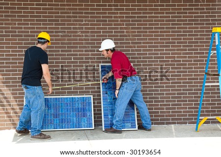 Workers measuring and installing solar electric panels.