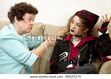 Angry mother pointing the finger at her rebellious teenage daughter.  Focus on the mom.