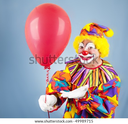 Friendly clown hands you a bright red balloon.