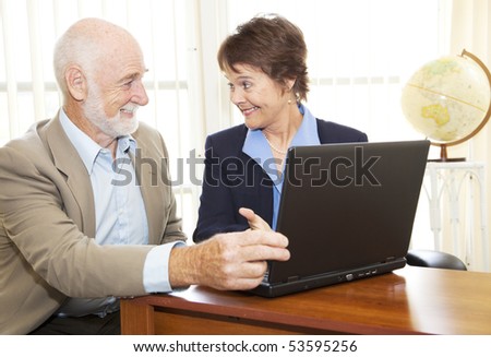 Mature businesswoman giving financial advice to senior man.