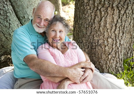 Beautiful senior couple in love, embracing under a tree.