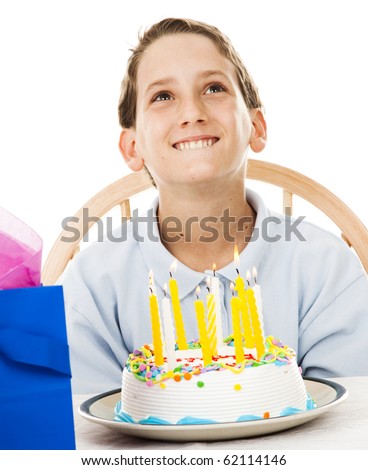 Cute little boy making a birthday wish before blowing out the candles on his cake.  White background.