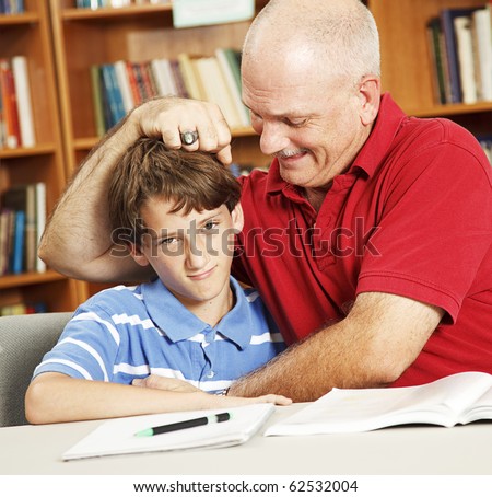 Father takes a break from helping his son with homework to give him noogies.
