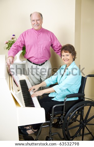Pretty church pianist in wheelchair, playing piano while a singer turns pages for her.