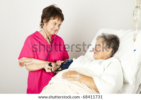 Nurse takes a senior patient\'s blood pressure in the hospital.