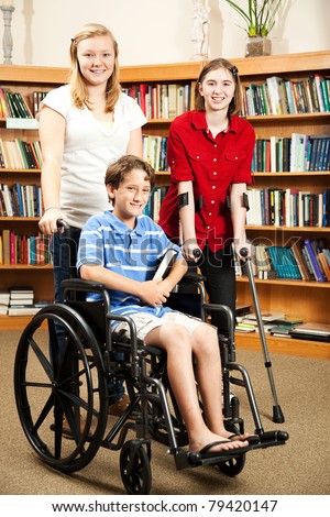 Group of teens in the library - one is in a wheelchair, one is on hand crutches.