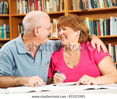 Mature couple has fun studying together at the library.