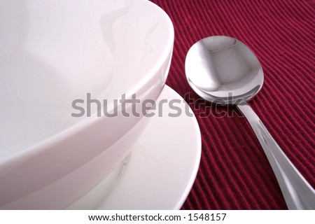Soup Spoon and Empty Bowl on a Burgundy Place Mat