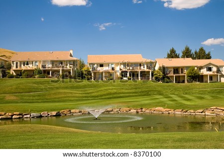 Adobe style homes at a country club, with a golf course and fountain.
