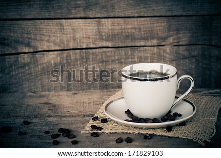 Dark coffee, coffee beans on jute cloth wooden table