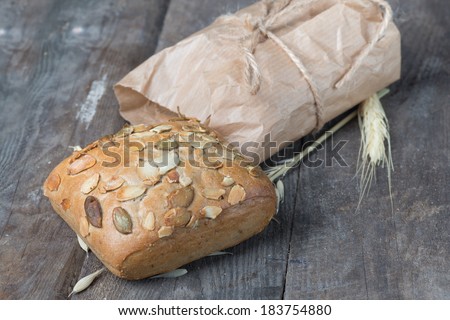 Delicious ciabatta packed in paper on a wood table