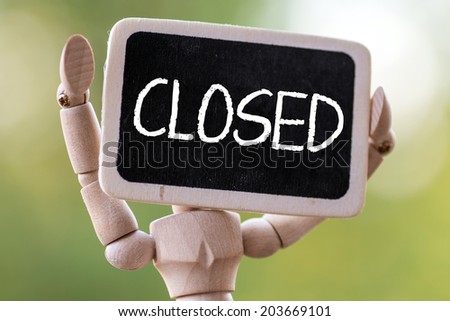 A wooden man holds a slate ready to deliver your message.Closed