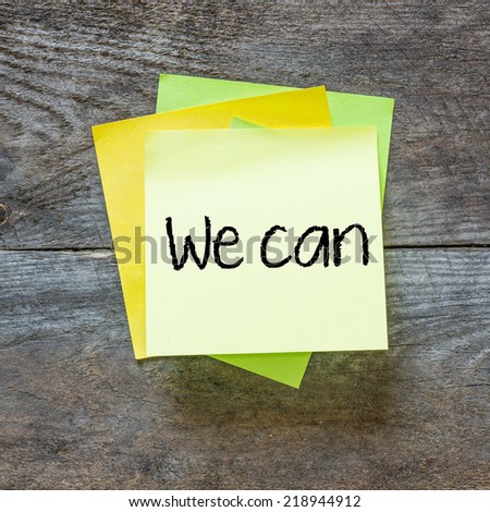 We can - motivational slogan on a stack of sticky notes posted on cork bulletin board
