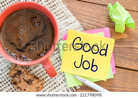 Good job noted on desk with coffee biscuit and pen,Office concept