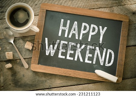 Happy Weekend. Blackboard with Happy Weekend sign and cup of coffee on wooden background