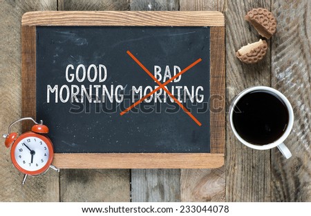 Bad morning crossed and good morning crossed sign on blackboard with cup of coffee ,cookie and clock on wooden background