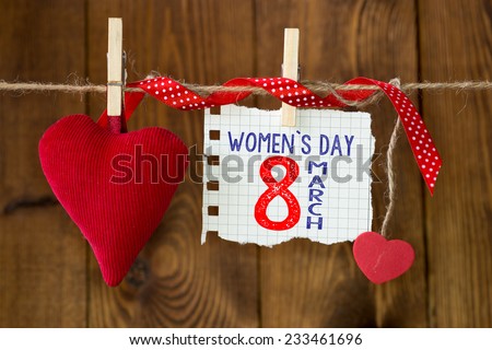 Happy Women's Day. Happy Women's Day on paper , hanging on a rope with red hearts.
