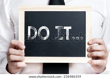 Do it background . Idea. Businessman holding board on the background with do it word