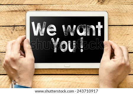We want you On PC. Hands with Tablet PC with We want you! text on wooden background