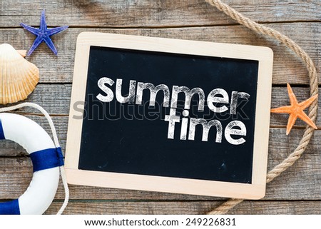 Summer time Text on blackboard. Marine items and blackboard with summer time text on wooden background. Sea objects on wooden plank.