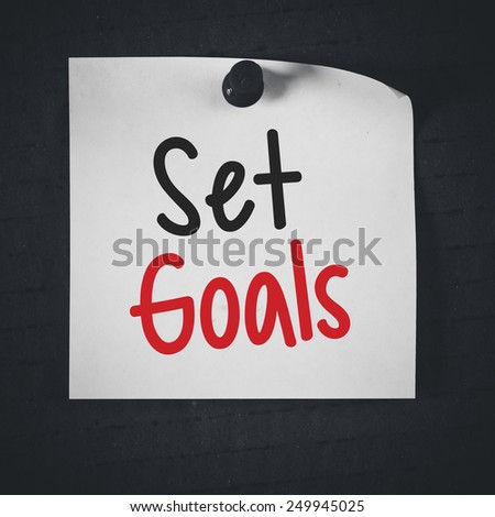 Note paper with set goals. White stick note paper with set goals on blackboard background