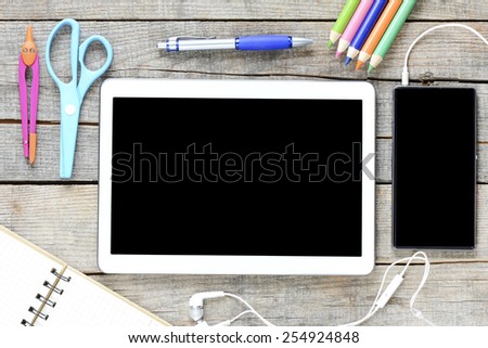 Tablet pc and office supplies. Empty tablet pc and office supplies on wooden background