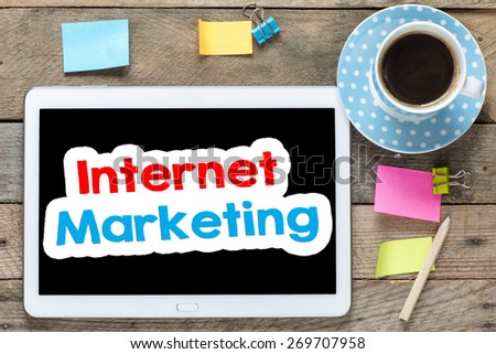 Internet marketing on Tablet computer. Tablet computer with stickers,cup of coffee and internet marketing on the wooden table
