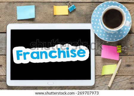 Franchise on Tablet computer. Tablet computer with stickers,cup of coffee and franchise on the wooden table