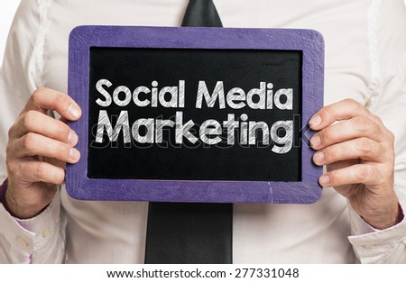 Businessman holding board with social media marketing