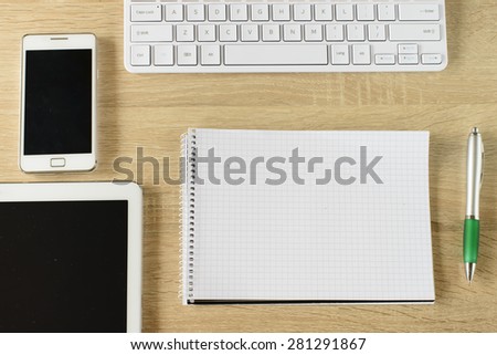 Tablet pc,smart phone,notebook and keyboard  on wooden background