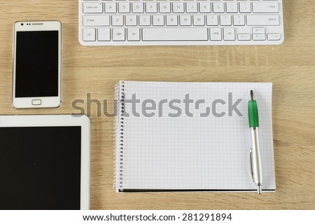 Tablet pc,smart phone,notebook and keyboard  on wooden background