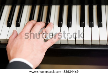 Hand playing music on the piano, hand and piano player