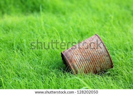 rusty can on green field