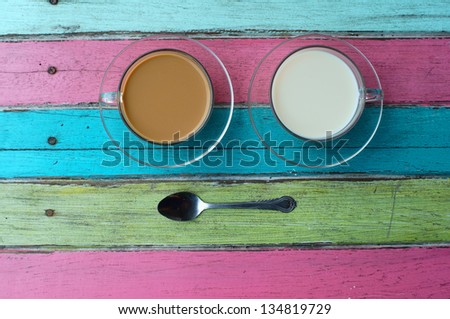 coffee and milk on colorful wooden background.
