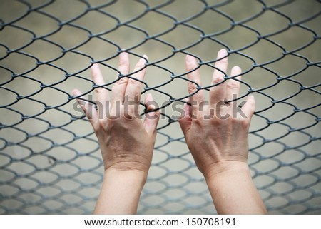 Hand touching iron mesh