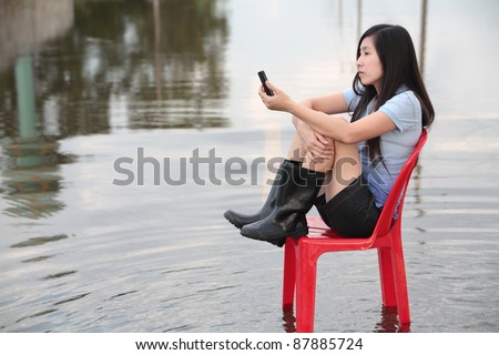 girl sitting on red chair,waiting for mobile phone signal.