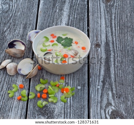 Bowl of clam chowder soup on reclaimed wood background