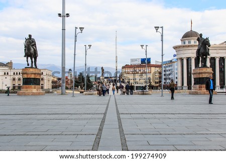 SKOPJE, MACEDONIA- March 20, 2014: Square Makedonia, the capital\'s main square, with people passing by and Stone Bridge on background.