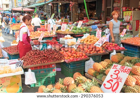 Kaohsiung, Taiwan - June 22,2015: People selling and buying food in a traditional fruit and vegetable market of Taiwan
